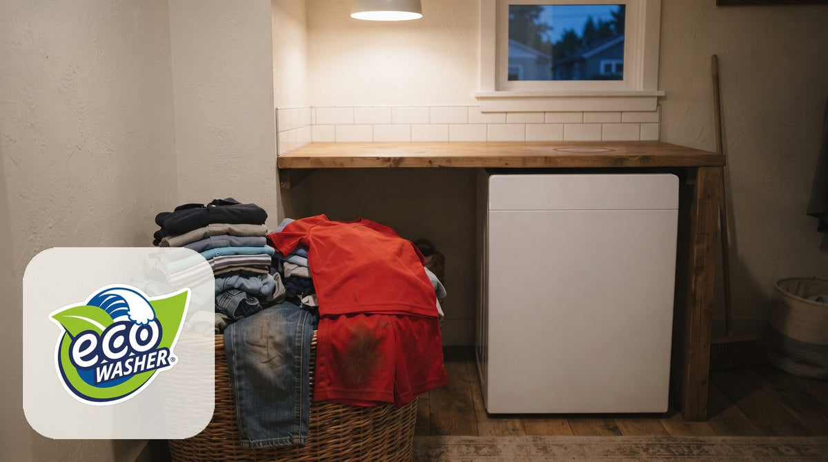 Laundry nook at night, out of detergent, with a basket of kids' shirts and a soccer jersey by a white washer
